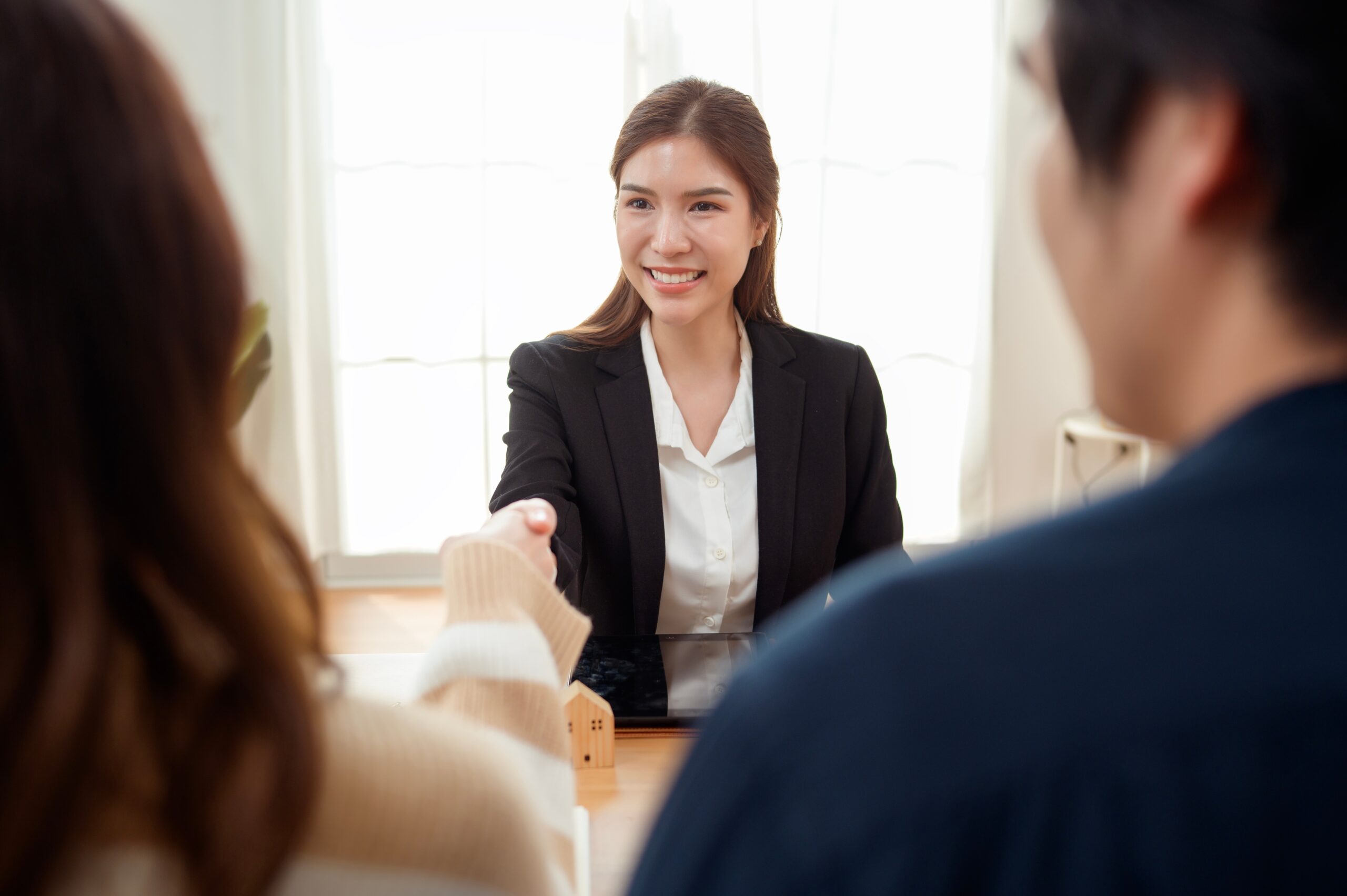 A sales representative shaking hands with her customers during face-to-face marketing.