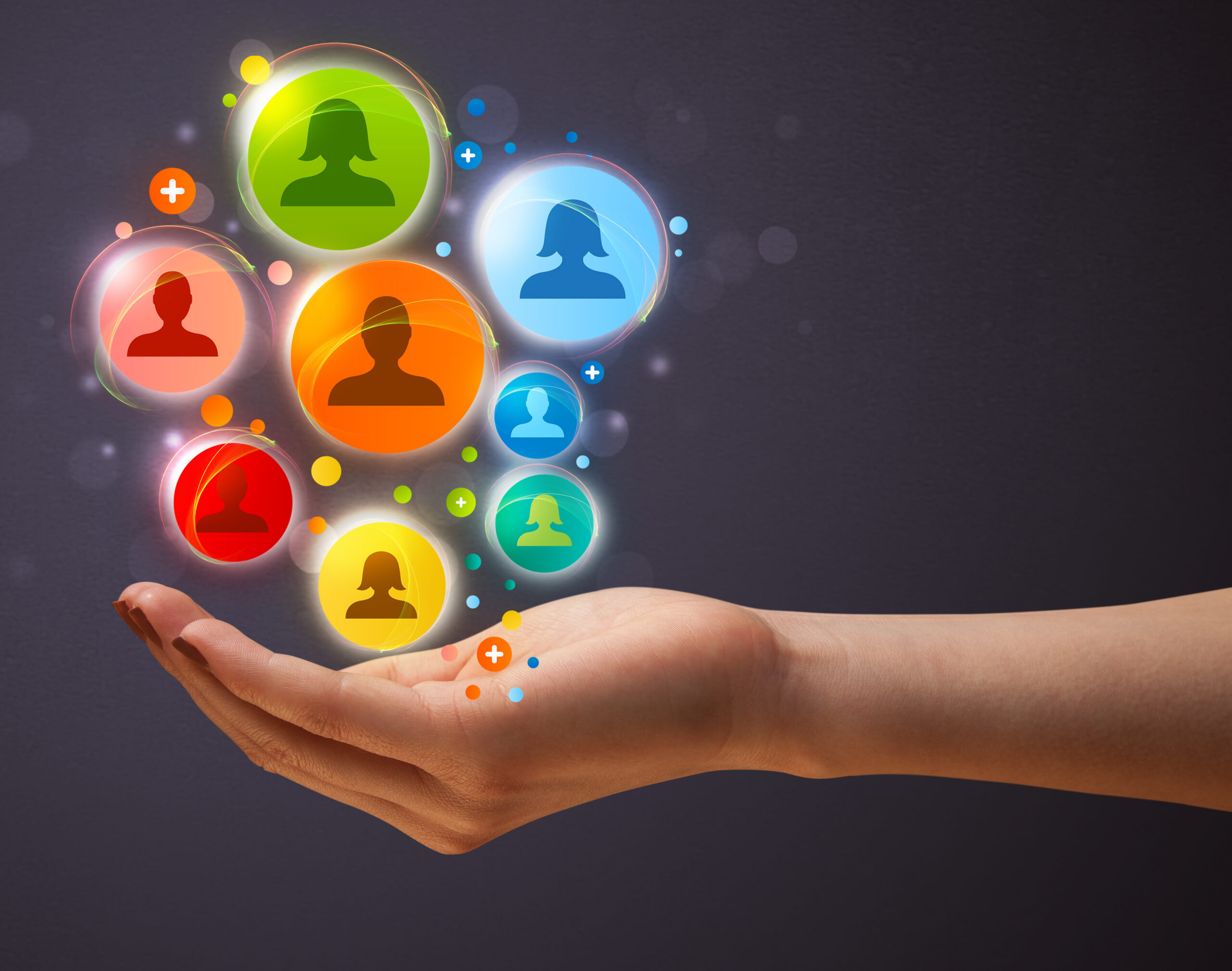 A hand holding connected people icons symbolizes how customer engagement builds meaningful relationships.